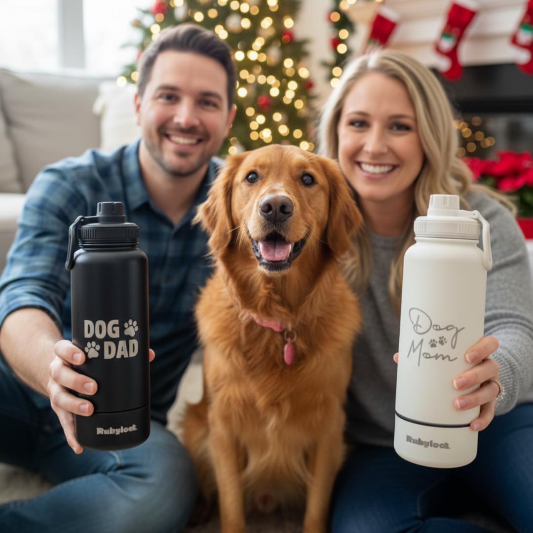 Two people holding water bottles with a dog between them, Christmas decorations in the background